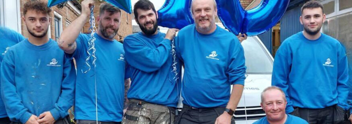 safe and healthy homes team in their blue branded t-shirts with a 10th anniversary blue above