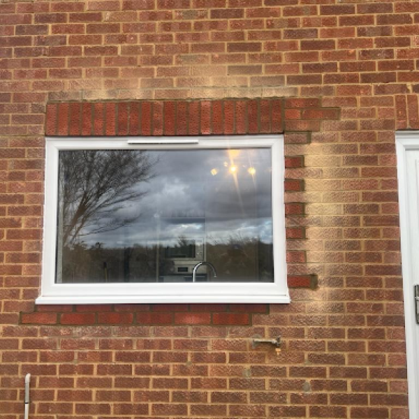 A brick house featuring a window and door, showing quality in general building and construction services