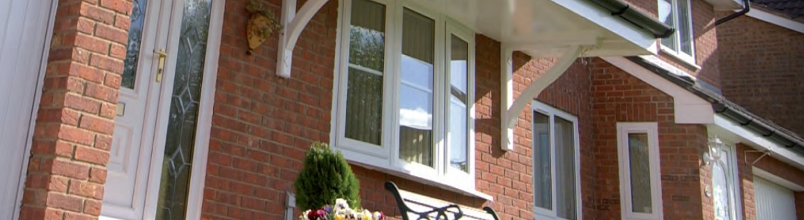 red brick house featuring white windows and a white door