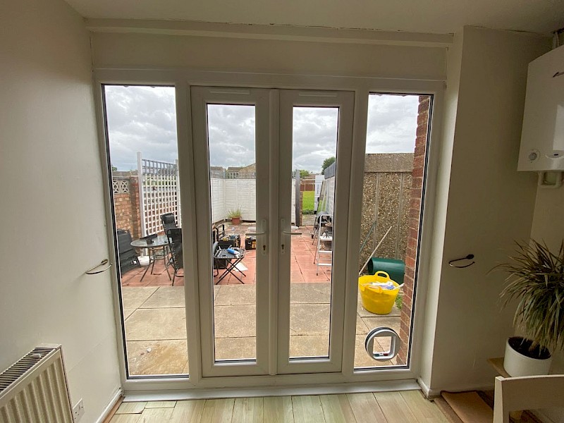 Interior out to exterior view of white patio doors installation