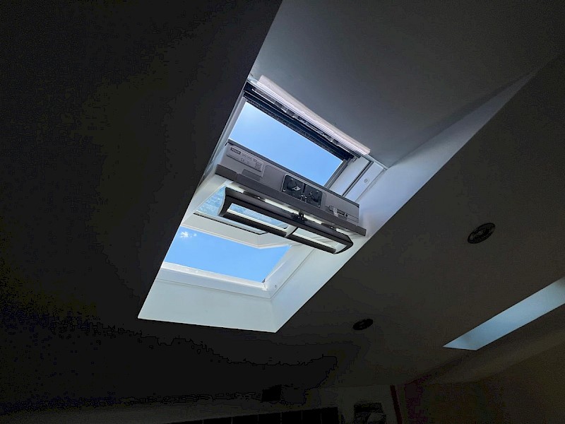 New skylight roof window installation with a view of the blue sky