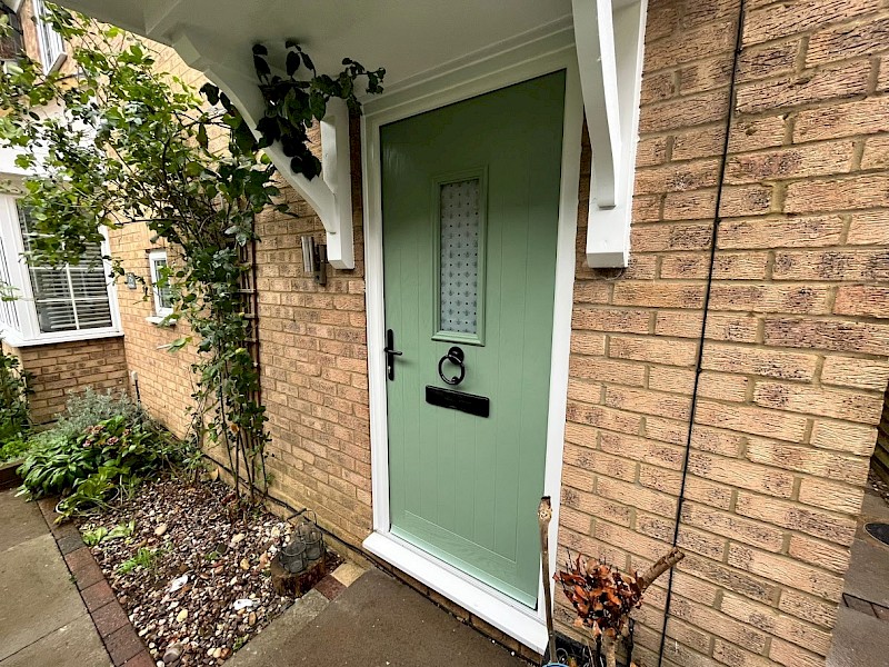 Brand new green front door of brick house recently installed