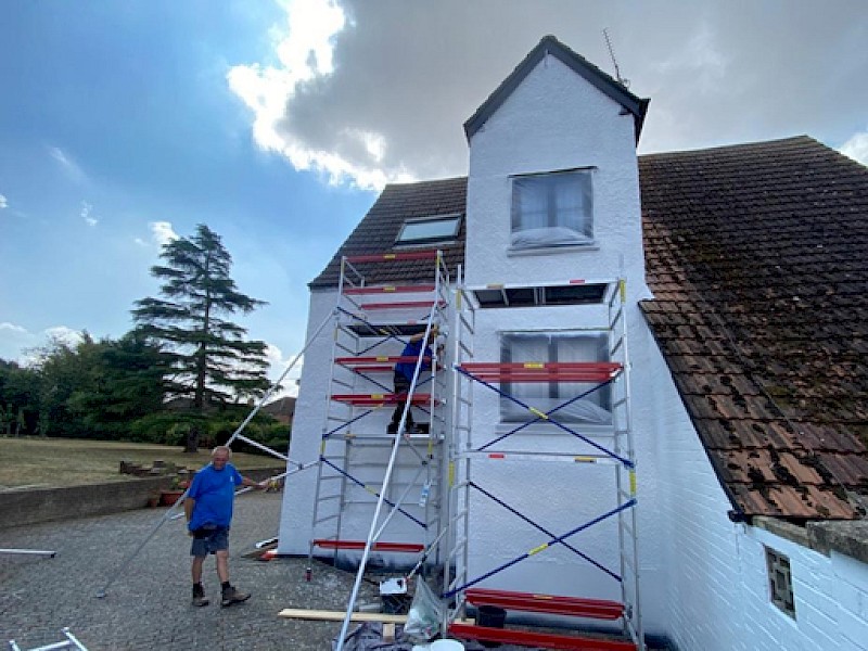 Exterior scaffolding showing painter and decorator painting the exterior of a home