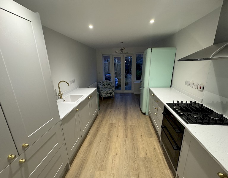 modern kitchen featuring a sink, stove, and oven, showcasing recent installation and repainting work