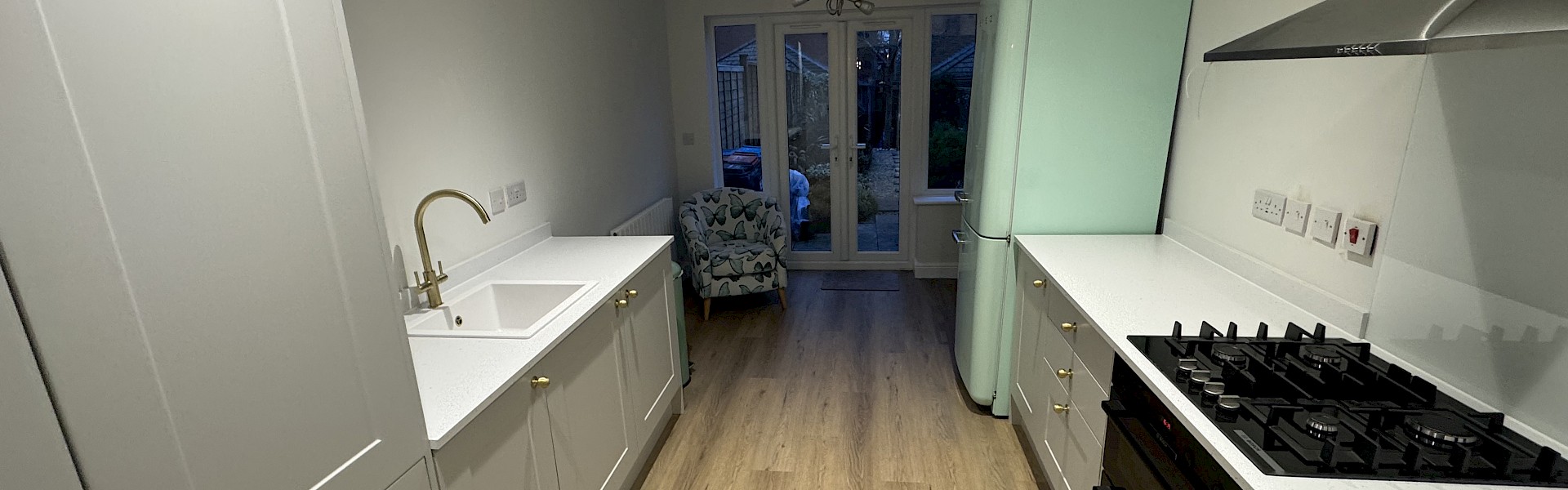 modern kitchen featuring a sink, stove, and oven, showcasing recent installation and repainting work