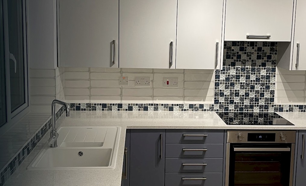 modern kitchen featuring a sink, stove, and oven, showcasing recent installation and repainting work