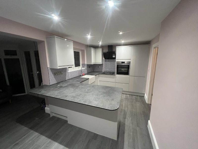 Contemporary kitchen showcasing a grey countertop and white cabinets, perfect for repairs and replacement worktops