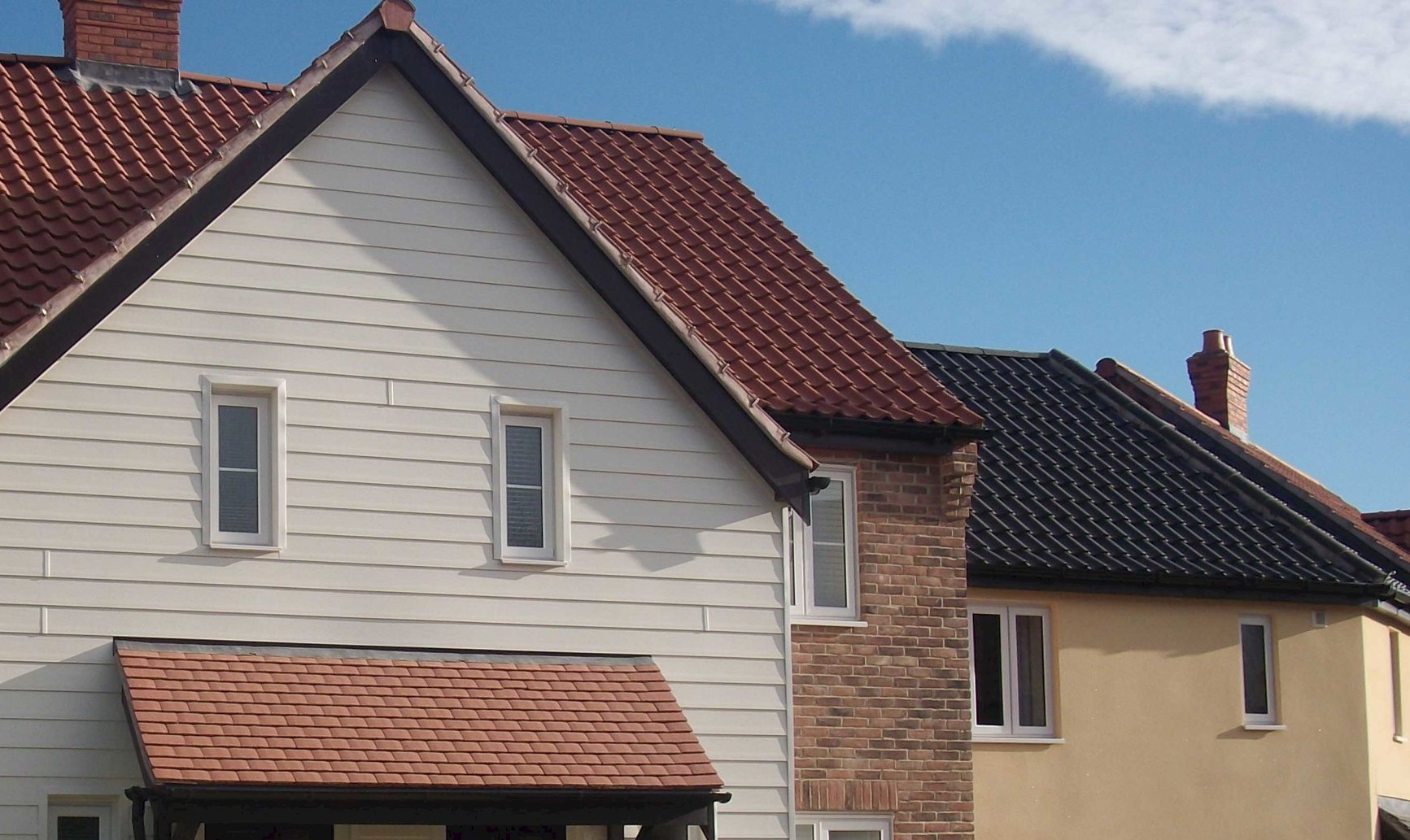 house featuring a red roof, showcasing roofline facias, soffits, and guttering services