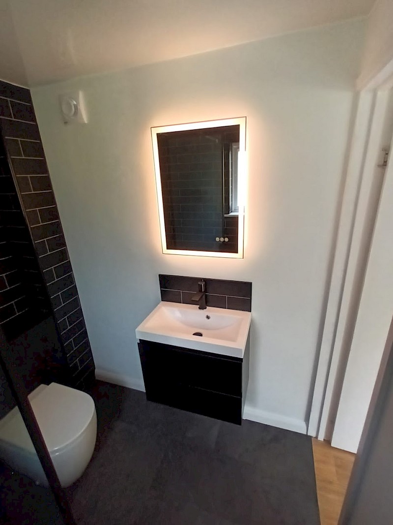 sleek modern bathroom featuring a glass shower, showcasing contemporary design and renovation excellence