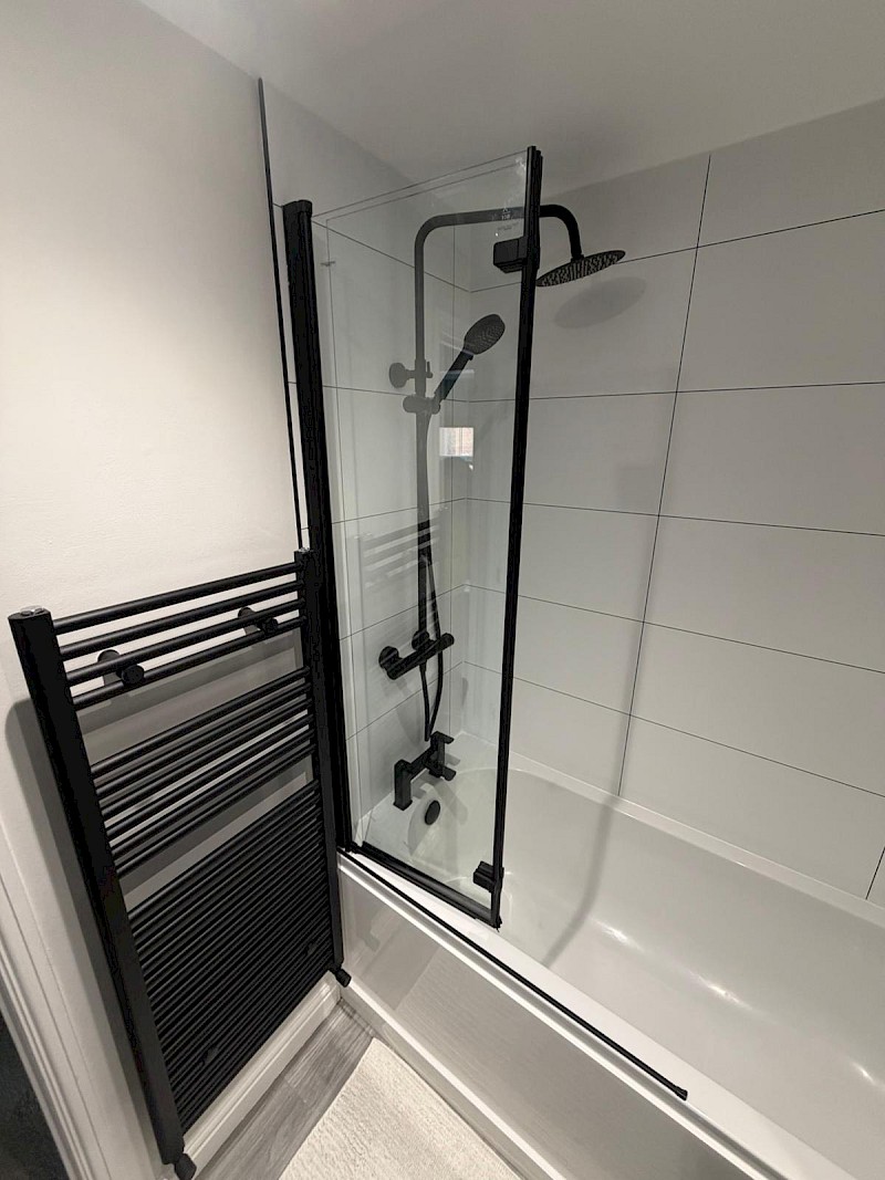 sleek modern bathroom featuring a glass shower, showcasing contemporary design and renovation excellence