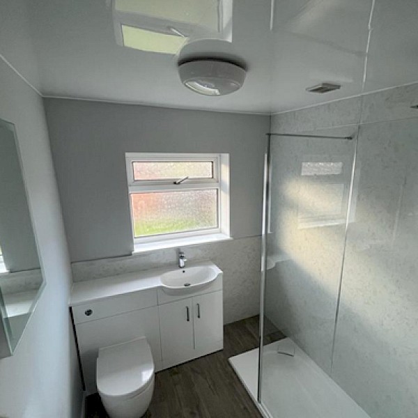 modern bathroom featuring a shower, toilet, and sink, showcasing quality installation and renovation work