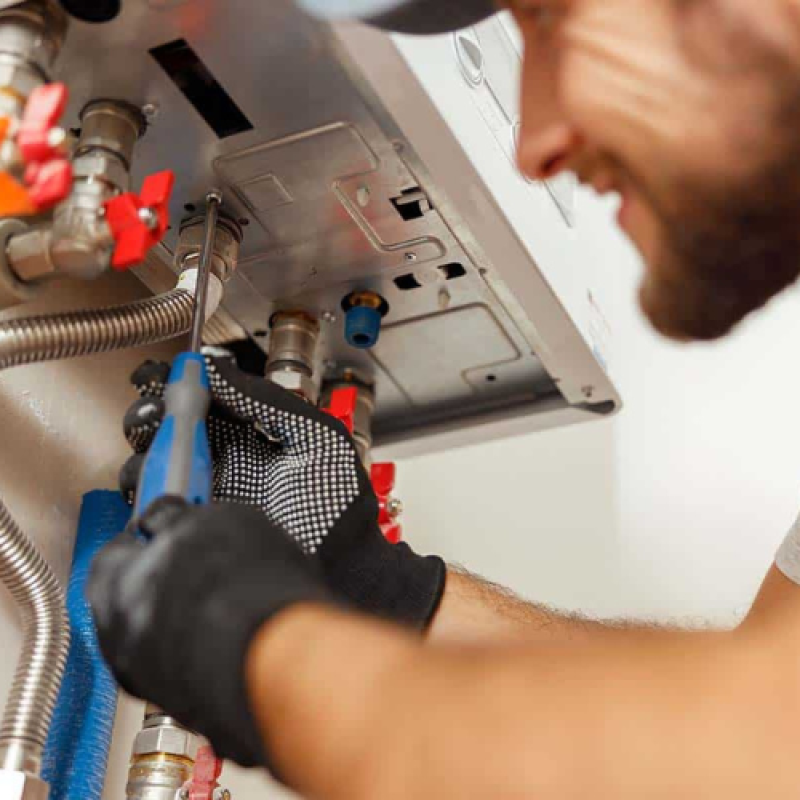 handyperson technician repairs a water heater, showcasing expertise in plumbing and gas services for efficient home maintenance