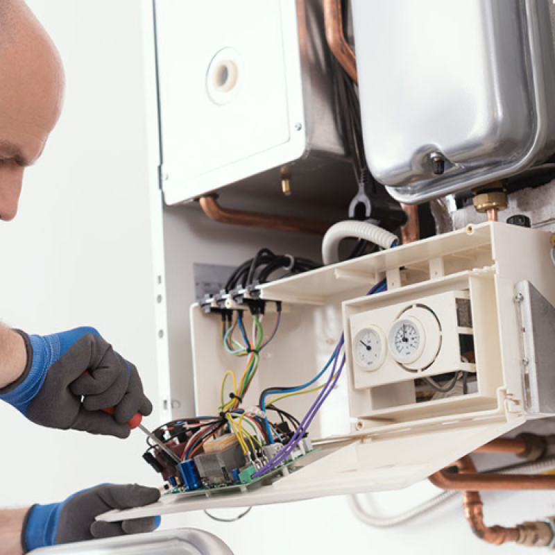 skilled technician performs maintenance on a gas boiler, showcasing expertise in plumbing and gas services.