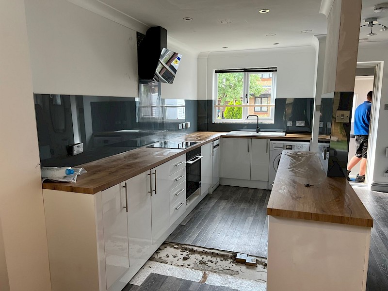 modern kitchen featuring a wooden countertop and white cabinets, ideal for installation and renovation projects