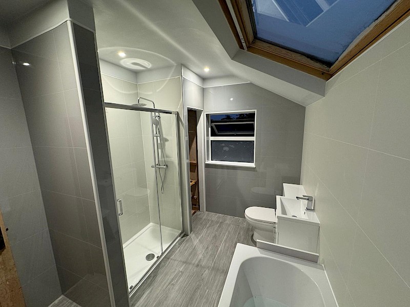 stylish bathroom featuring pink tile walls and a bathtub, showcasing modern installation and renovation elements