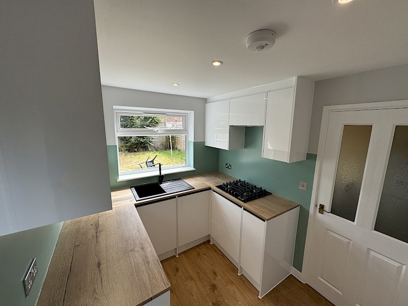 Contemporary kitchen showcasing a grey countertop and white cabinets, perfect for repairs and replacement worktops