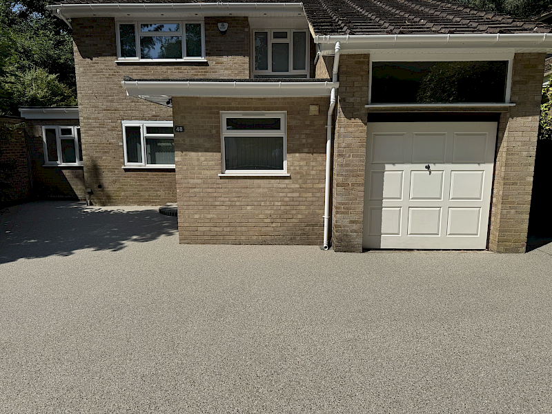 Resin bound driveway at a brick family home in Bedfordshire, providing a smooth, attractive and seamless surface across the driveway and garage entrance.